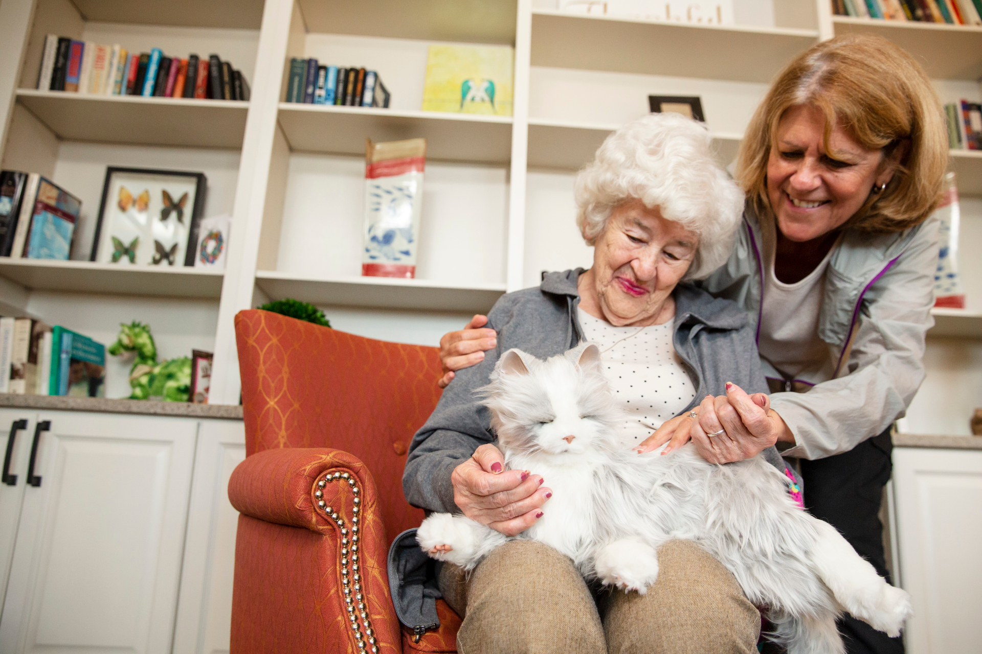 Nursing home resident smiling while holding a companion cat